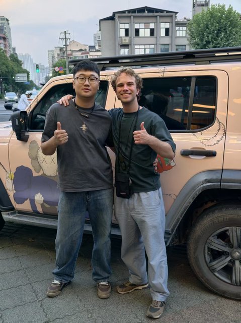 Two travelers with a decorated car in Chengdu