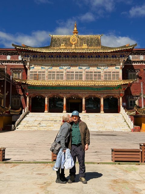 Couple kissing in front of a Tibetan monastery