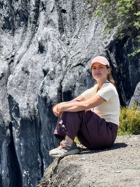 Traveler sitting on a rock ledge in Western Sichuan