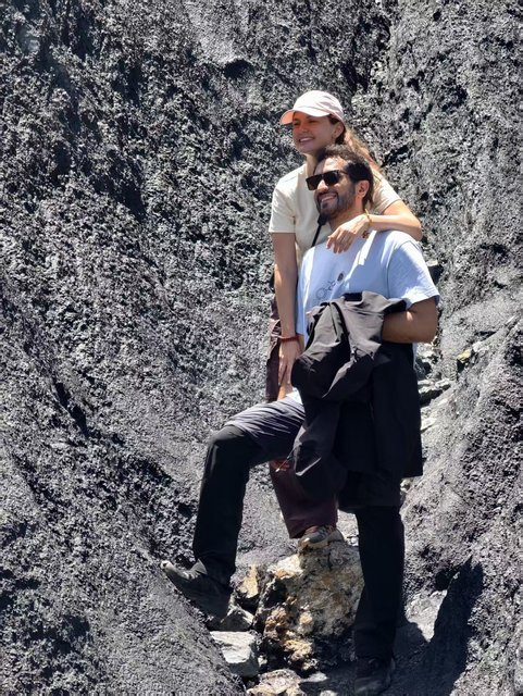 Couple climbing volcanic rock together