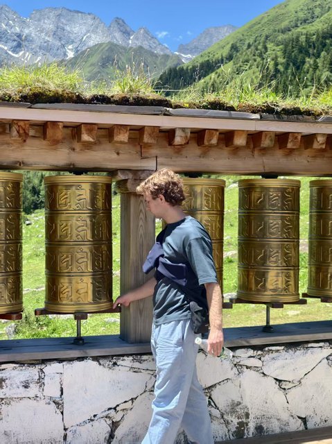 Traveler among golden prayer wheels