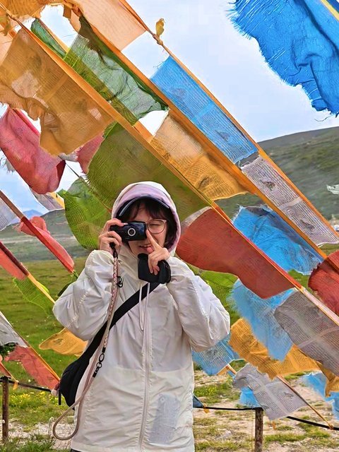 Traveler taking a photo under prayer flags